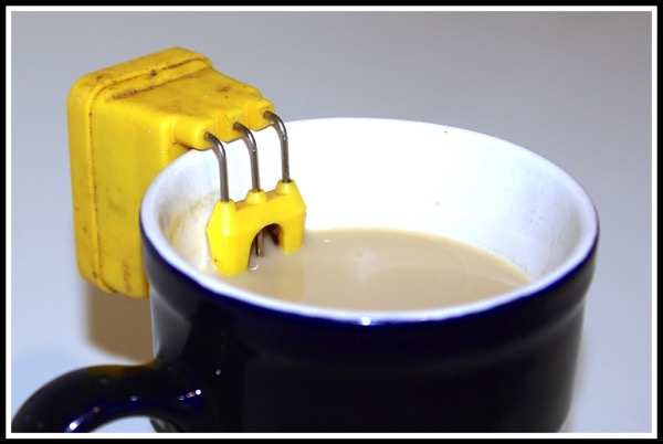 a liquid level indicator attached to the side of a blue cup filled up with tea