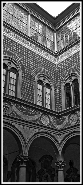 Black and white photo taken from the inner courtyard looking up to the roof of the Palazzo Medici Riccardi arches 2