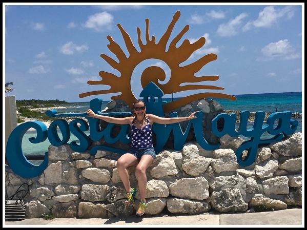 SARAH SAT IN FRONT OF A LARGE COSTA MAYA SIGN WITH THE LOVELY BLUE SEA IN THE BACKGROUND